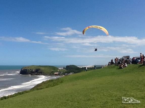 Em dia de céu azul e muito vento, feriado de carnaval, as pessoas aproveitam para saltar de paraglider do alto do Morro do Farol, em Torres, litoral norte do Rio Grande do Sul